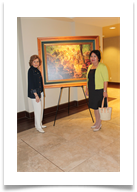 Consul General Gina Jamoralin and Raqui pose beside THE LAST CAVALRY CHARGE from the Hawaii Army Museum